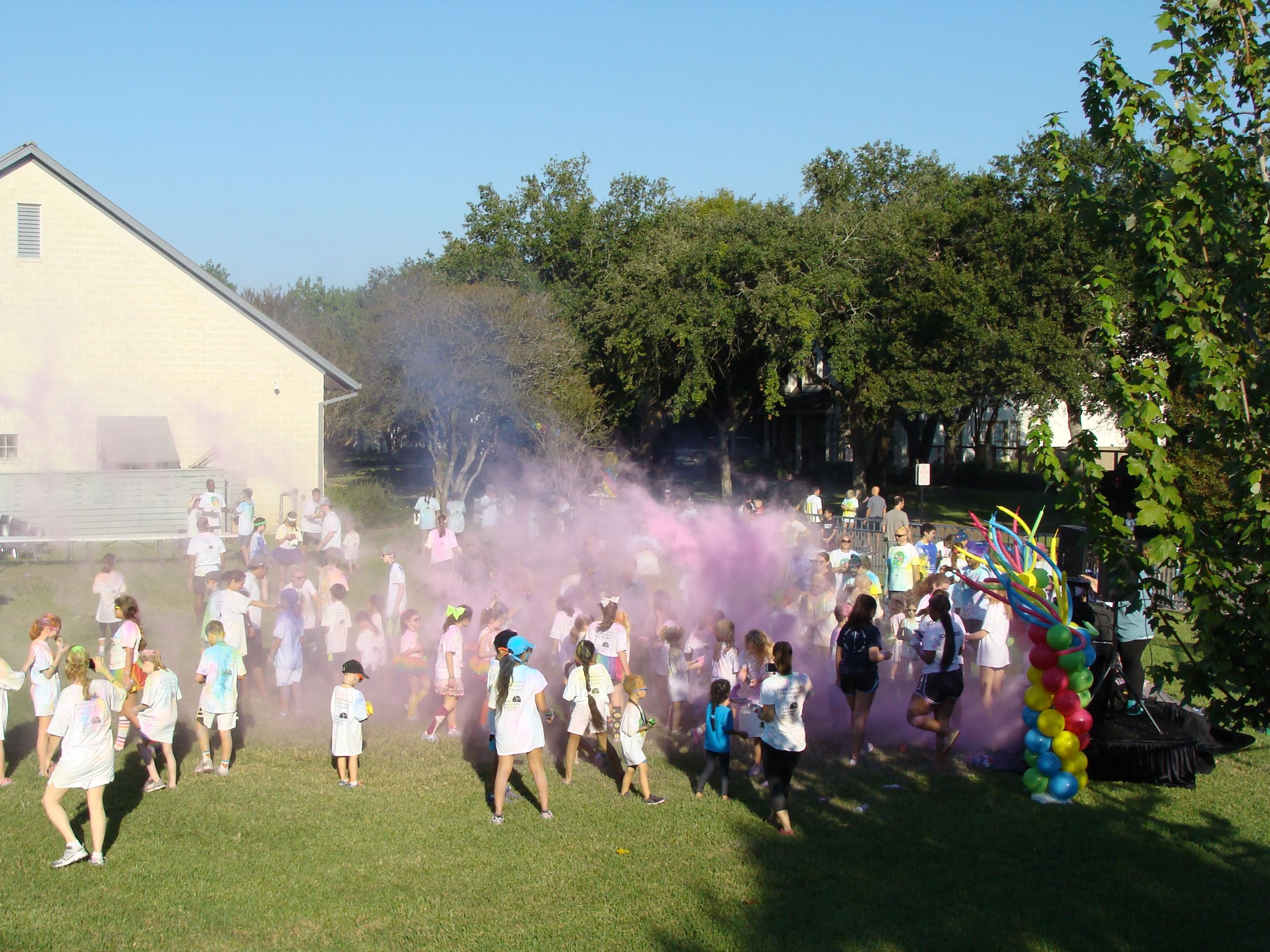 Large group of children under clouds of color powder